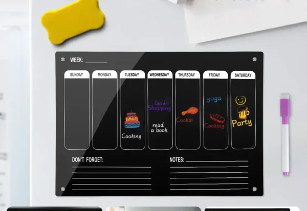 Tableau magnétique semaine noir avec jours de la semaine, marqueur et gomme, fixé sur porte réfrigérateur.